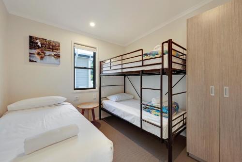 a bedroom with two bunk beds and a bed at Discovery Parks - Pambula Beach in Pambula