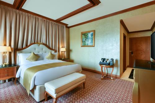 Al Aziziyah Boutique Hotel في الدوحة: غرفه فندقيه سرير وتلفزيون