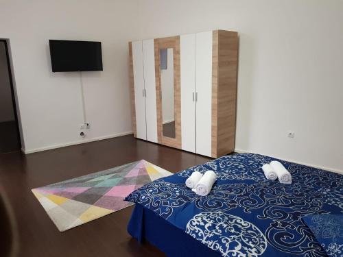 um quarto com uma cama e uma televisão na parede em Apartament 12 Central em Târgu-Mureş