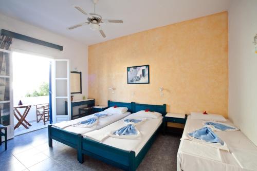 a room with two beds and a balcony at Villa Anna Maria in Aliki