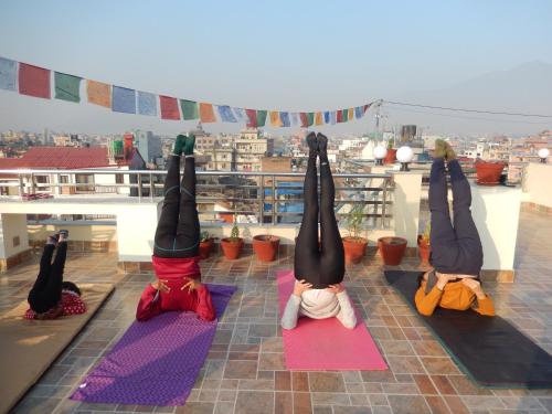 a group of people doing yoga on a roof at Shine Homestay Famille Francophone - Shine Home and Apartment in Kathmandu
