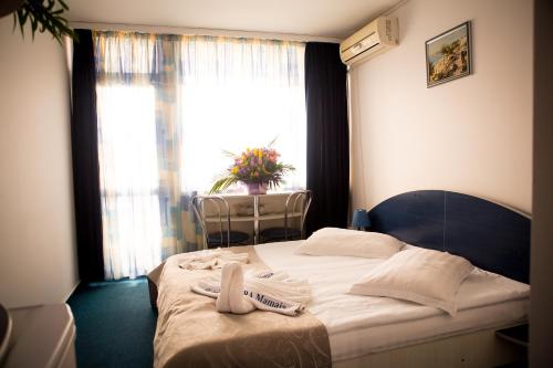 Un pat sau paturi într-o cameră la Hotel Aurora