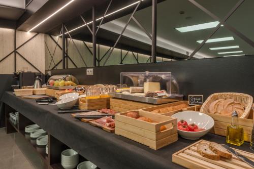 una línea de buffet con muchos tipos diferentes de comida en Hotel Olot Centre en Olot