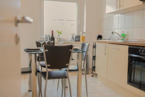 a kitchen with a table with chairs and wine glasses at Blue Chili 01 - TOP City Lage am HBhf Boxspringbett bis 4 Pers in Magdeburg