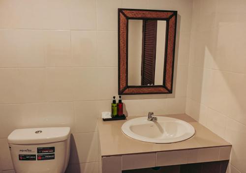 a bathroom with a sink and a toilet and a mirror at High Life Bungalow in Haad Yao