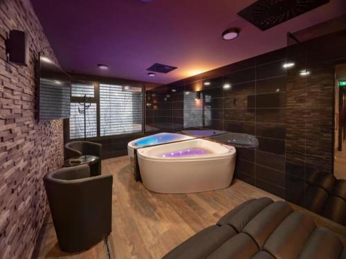 a large bathroom with a tub in a room at Wellness Hotel Astra in Špindlerův Mlýn