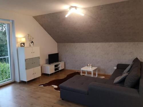ein Wohnzimmer mit einem Sofa und einem Tisch in der Unterkunft Haus am Hang; Ferienwohnung Fernblick in Stolberg