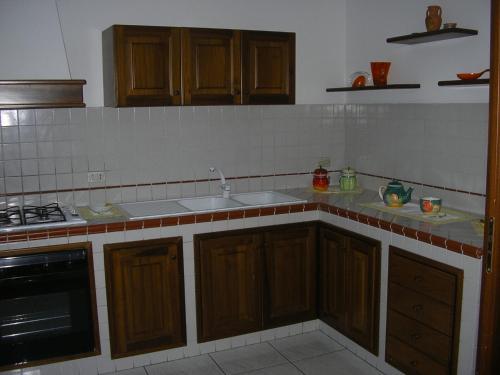 a kitchen with wooden cabinets and a sink at Terrazza Sul Mare in Gioiosa Marea