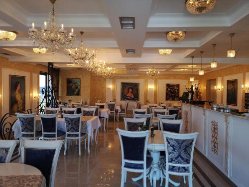 a dining room with tables and chairs and chandeliers at Adonis 201 in Zlatibor