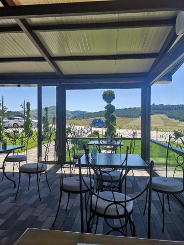 a patio with tables and chairs and a view at Adonis 201 in Zlatibor