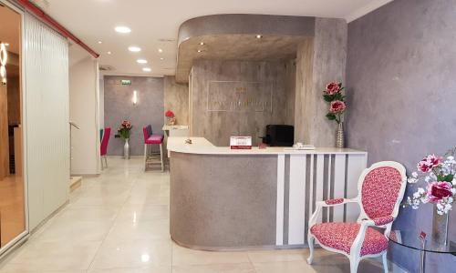 un vestíbulo con un mostrador con sillas y flores en Hotel Avenida Plaza, en Alzira