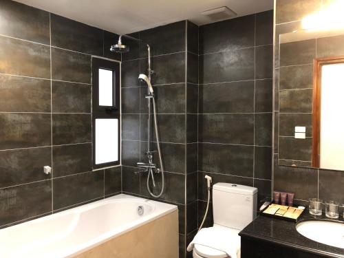 a bathroom with a tub and a toilet and a sink at Moc Hoang Hotel in Hanoi
