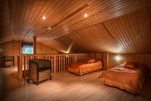 a bedroom with two beds in a wooden cabin at Juhlamenot Oy in Söderkulla