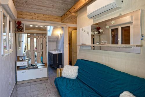 un salon avec un canapé bleu et une télévision dans l'établissement Le Coeur des Alpes, à Marnaz