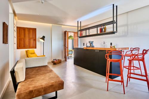 a kitchen and living room with a bar and stools at Lighthouse on La Palma Island in Barlovento