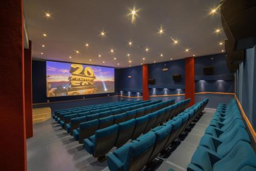 a theatre with blue chairs and a large screen at InterContinental Mzaar Lebanon Mountain Resort & Spa by IHG in Kfardebian