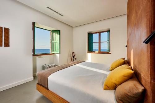 a bedroom with a bed and two windows at Lighthouse on La Palma Island in Barlovento