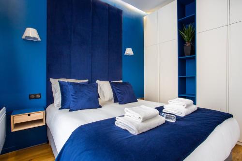 - une chambre bleue avec un lit et des serviettes dans l'établissement CMG - Grand Boulevard - Poissonière, à Paris