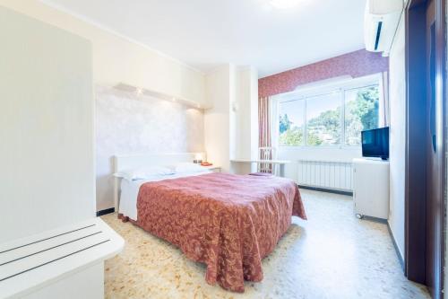 a bedroom with a bed and a large window at Gold Hotel in Bordighera