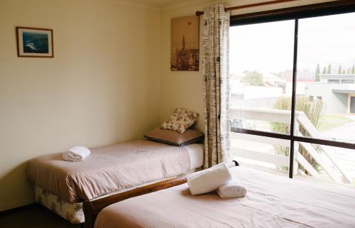 a bedroom with two beds and a large window at Apollo Stay in Apollo Bay