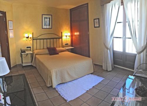 a bedroom with a bed and a window at HOTEL GUADALOPE in Alcañiz