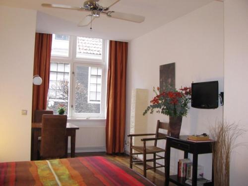 a living room with a bed and a table with a television at Prinsenstede Lodging Amsterdam in Amsterdam