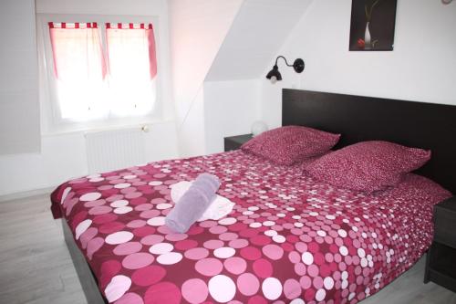 a bedroom with a pink bed with a stuffed animal on it at Gite de Puychevrier in Mérigny