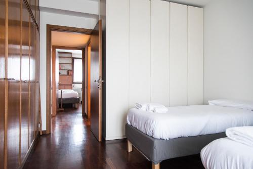 sypialnia z 2 łóżkami i drzwiami do pokoju w obiekcie YouHosty - Vittadini 5 w Mediolanie