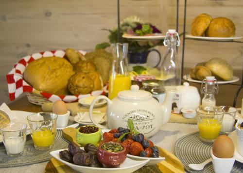 ein Frühstückstisch mit Eiern, Obst und einer Teekanne in der Unterkunft Bed & Breakfast De Stippelberg in Rips