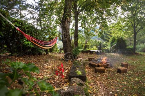a hammock hanging from a tree next to a fire at Ca' Lilli in Cantiano