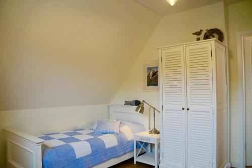 a bedroom with a bed and a white cabinet at Ferienhaus Windrose in Breege