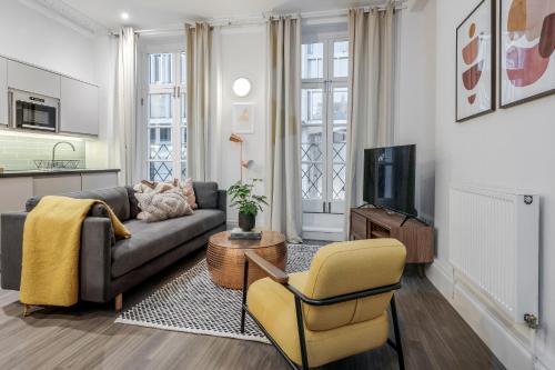 a living room with a couch and a tv at Stay Kula London - Victoria in London