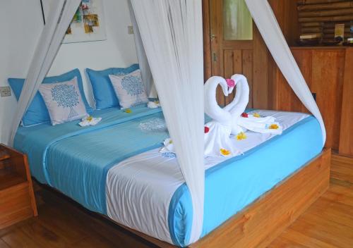 a bedroom with a bed with a swan on it at Lagoona Beach Bungalows - Eco Bungalows Batukaras in Batukaras