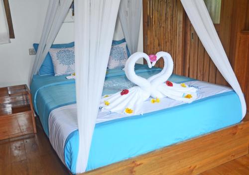 a bed with two swans made out of towels at Lagoona Beach Bungalows - Eco Bungalows Batukaras in Batukaras