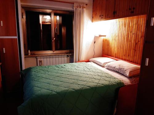 a bedroom with a green bed and a window at Paradiso Aremogna in Roccaraso