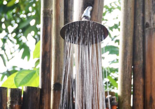a water hose hanging from a wooden fence at Lagoona Beach Bungalows - Eco Bungalows Batukaras in Batukaras