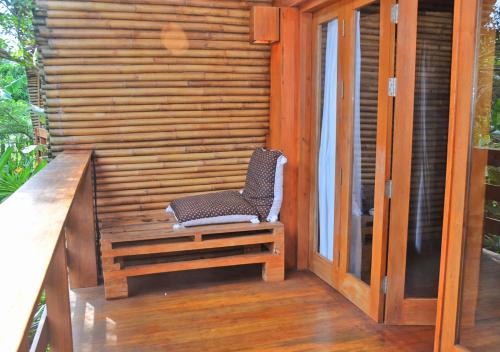 a chair sitting on the porch of a house at Lagoona Beach Bungalows - Eco Bungalows Batukaras in Batukaras