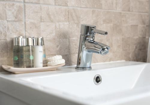 a bathroom sink with a faucet on top of it at Castle Suite 3 Old Town in Edinburgh