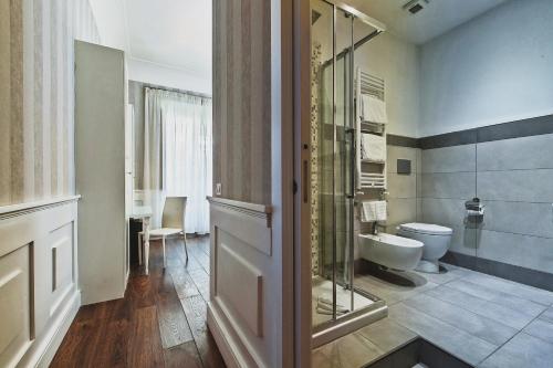 a bathroom with a toilet and a glass door at Star Vatican Rooms in Rome