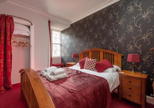 een slaapkamer met een groot bed en een rode deken bij Ladystairs 1 Royal Mile in Edinburgh