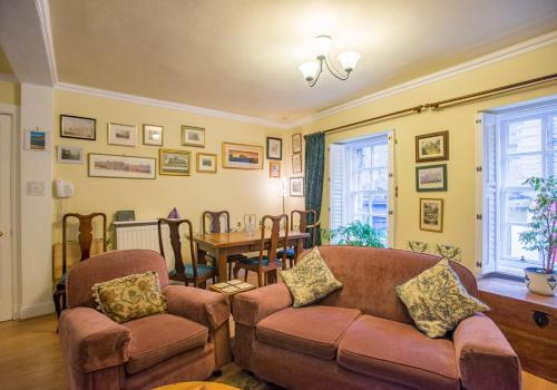 a living room with a couch and chairs and a table at Candlemaker Old Town 500m from Edinburgh Castle in Edinburgh