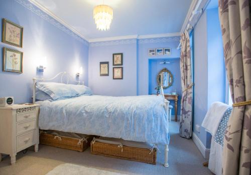 Dormitorio azul con cama y espejo en Candlemaker Old Town 500m from Edinburgh Castle en Edimburgo