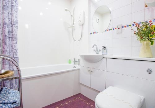 La salle de bains blanche est pourvue d'un lavabo et de toilettes. dans l'établissement Candlemaker Old Town 500m from Edinburgh Castle, à Édimbourg