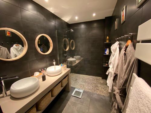 une salle de bain avec deux lavabos et deux miroirs dans l'établissement Rev'Azur, à Fréjus