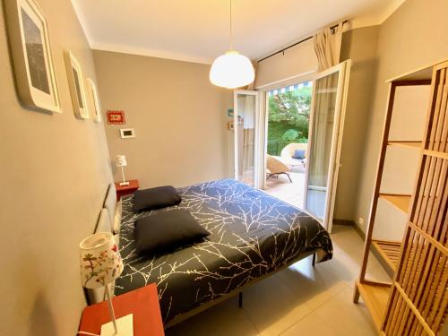 une chambre avec un lit et un balcon dans l'établissement Rev'Azur, à Fréjus