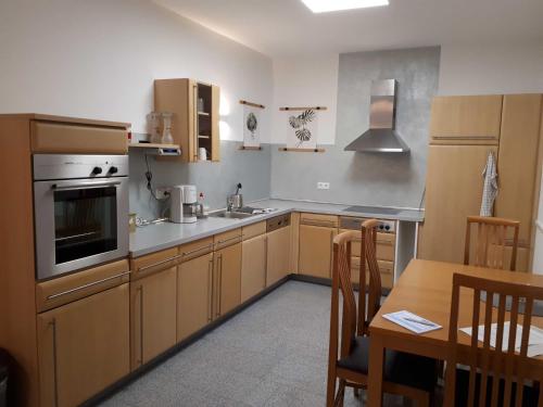 a kitchen with wooden cabinets and a table and a stove at Ferienhaus Frankenglueck in Egloffstein