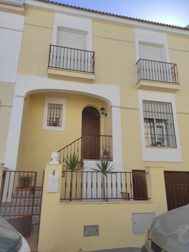 una casa con due balconi e una porta di Casa nueva en Urbanización la Biznaga a Sierra de Yeguas