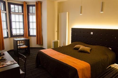 een hotelkamer met een bed met een kussen erop bij Le Vieux Beffroi in Béthune