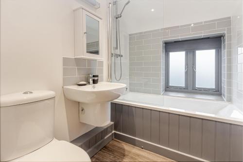 La salle de bains est pourvue de toilettes, d'un lavabo et d'une baignoire. dans l'établissement Guest Homes - Bridge Street Residence, à Leominster