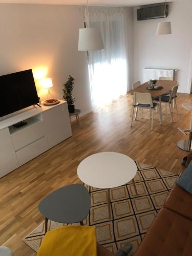 sala de estar con 2 mesas y TV en Eurorail logistics Apartment, en Zagreb